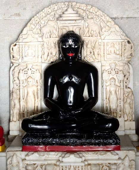 Intricately carved shrine backdrop and black idol inside the temple